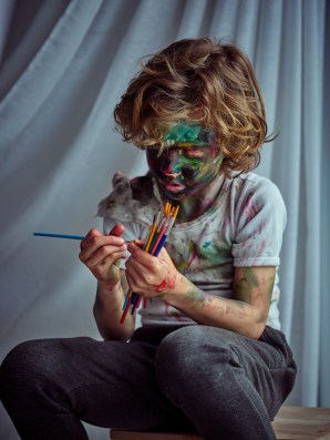 Mischievous boy covered with paints
